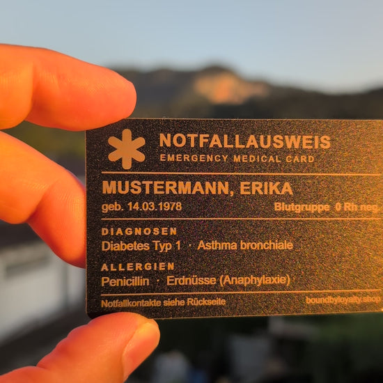 Notfallausweis aus Metall im Scheckkartenformat in der Hand