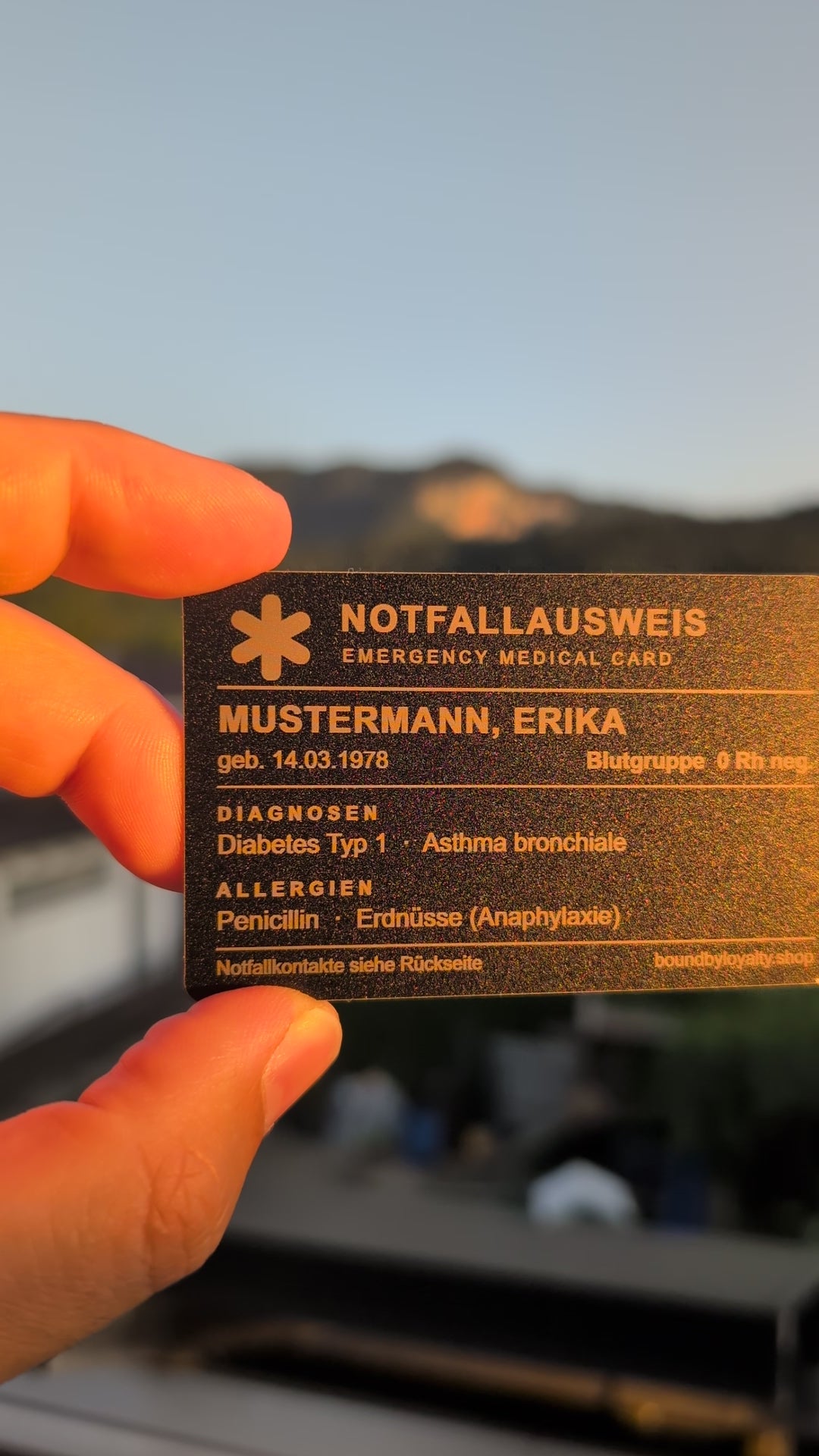 Notfallausweis aus Metall im Scheckkartenformat in der Hand